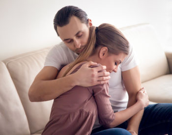woman and man hugging on a couch
